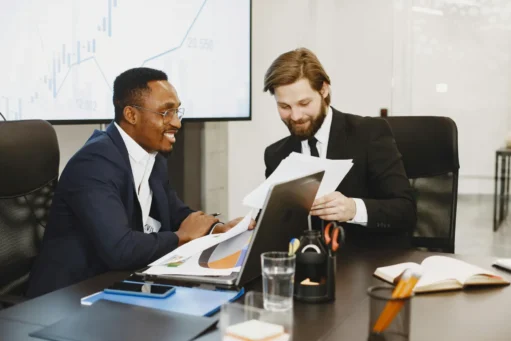 como-vender-pela-internet-sem-ter-loja-virtual dois homens sorrindo com papéis em um escritório