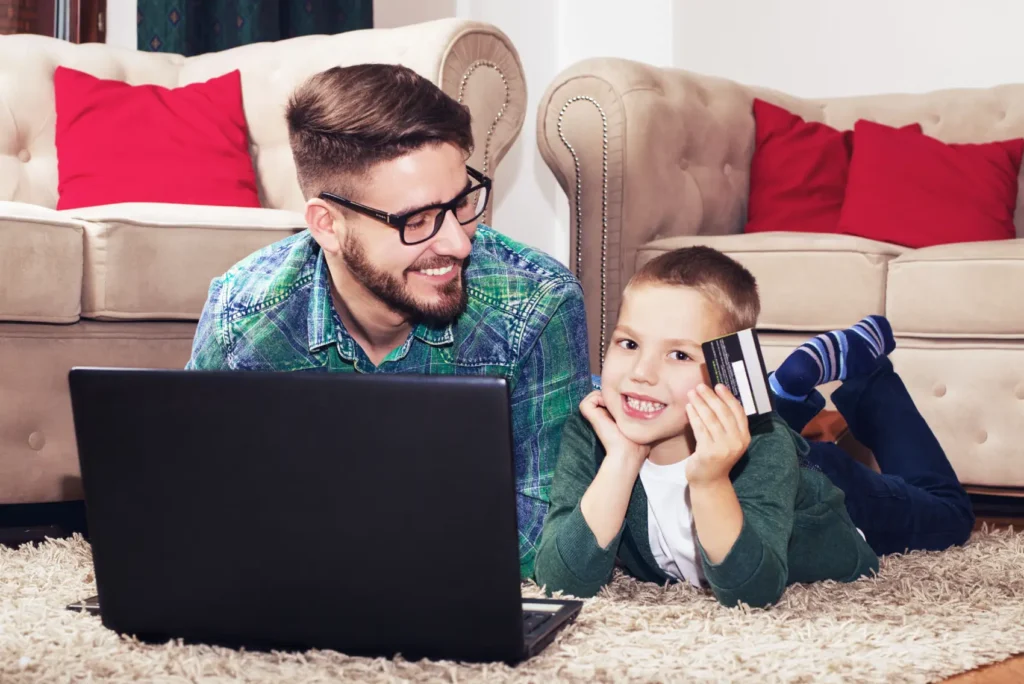 dia dos pais online - Pai e filho usando notebook para fazer compras online