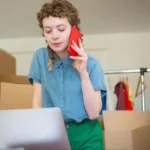 o que é gateway - mulher fala ao telefone enquanto mexe no notebook