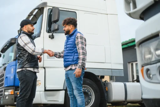mei caminhoneiro - Dois motoristas de caminhão homens apertando as mãos, simbolizando o acordo de negócios bem-sucedido e parceria na indústria de logística