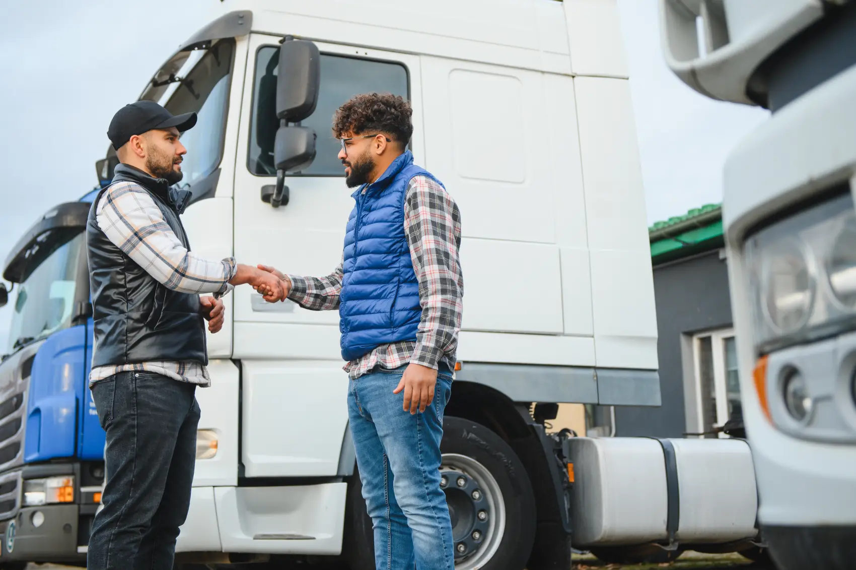 mei caminhoneiro - Dois motoristas de caminhão homens apertando as mãos, simbolizando o acordo de negócios bem-sucedido e parceria na indústria de logística