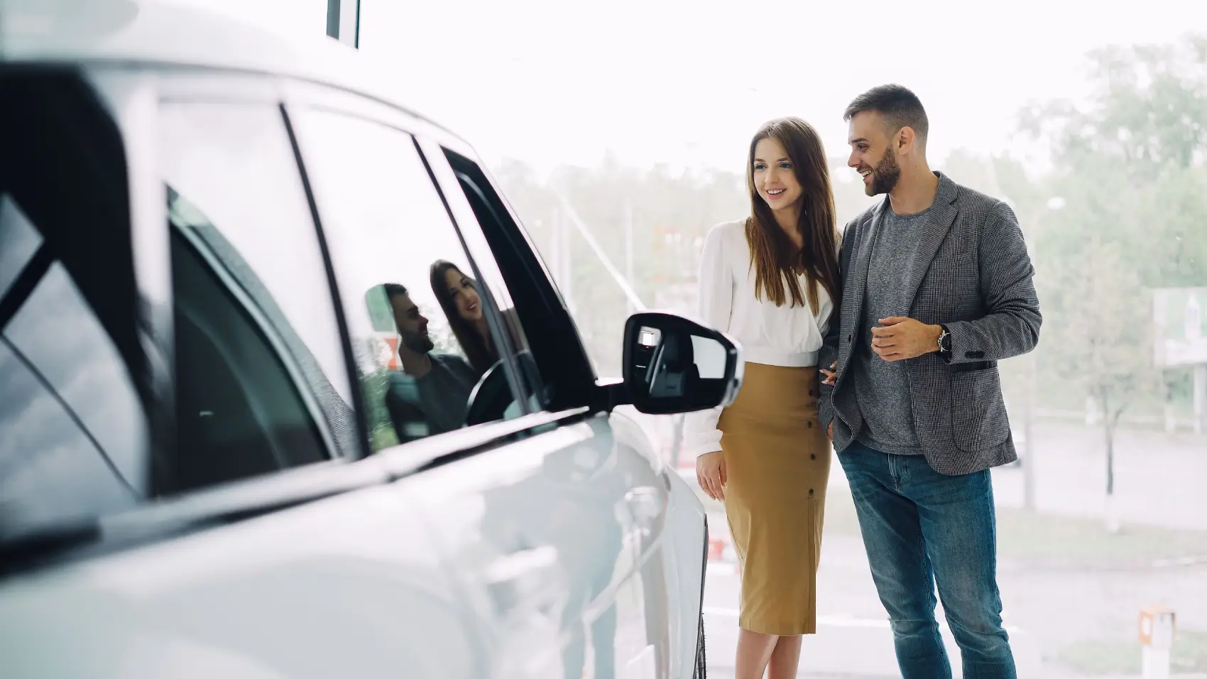 o-que-e-licenciamento-de-veiculos casal olhando para o carro parado na concessionária