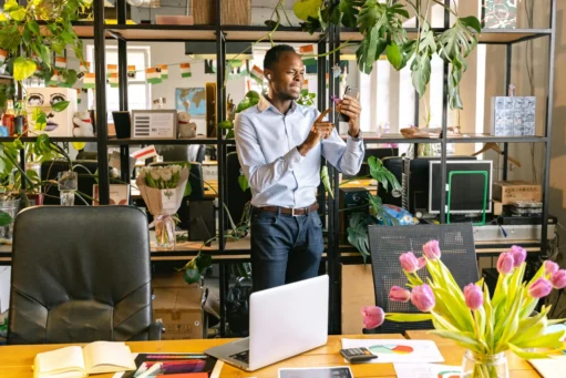 como-vender-pela-internet homem com smartphone no escritorio com notebook na mesa