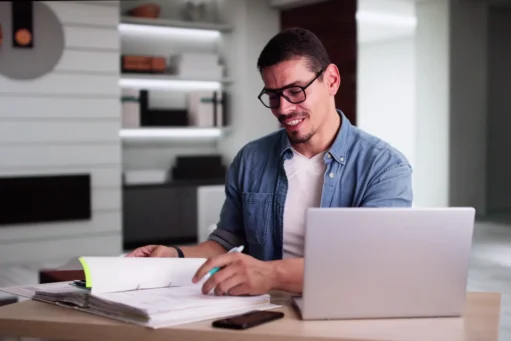 carnê leão - homem latino calculando finanças online usando laptop