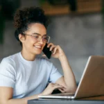 freelancer mulher olhando notebook e falando no celular