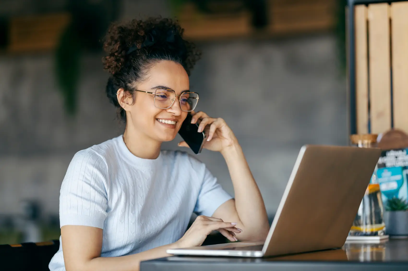 freelancer mulher olhando notebook e falando no celular