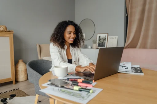 como-abrir-cnpj mulher sorrindo com notebook na sua frente em uma mesa de escritório