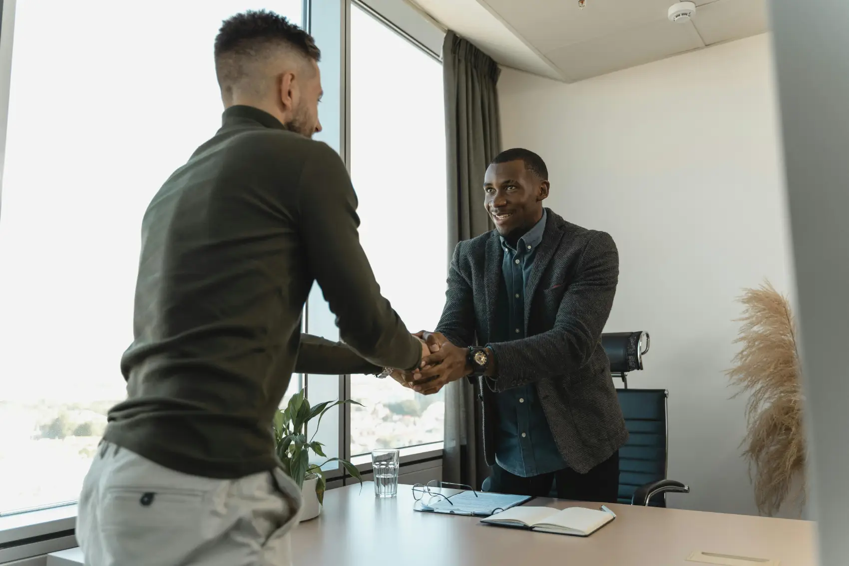 como-prospectar-clientes dois homens se cumprimentando em escritório