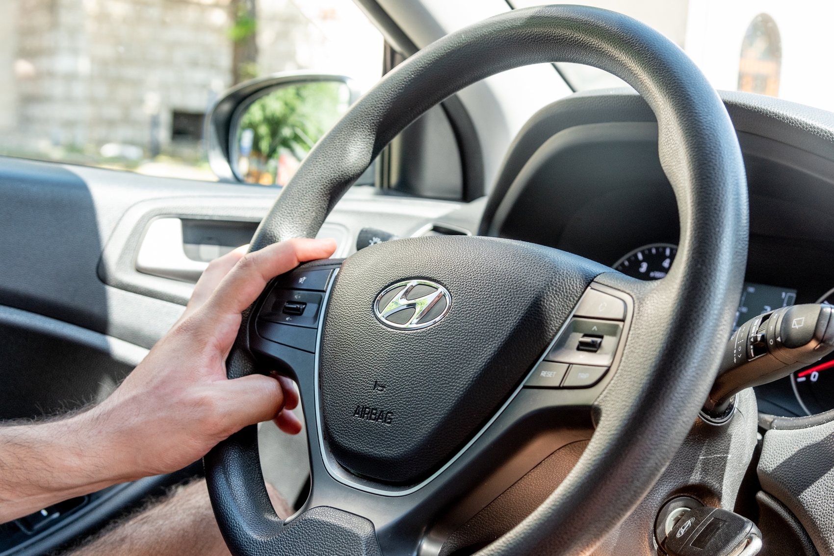 IPVA - Homem motorista segurando o volante do carro Hyundai