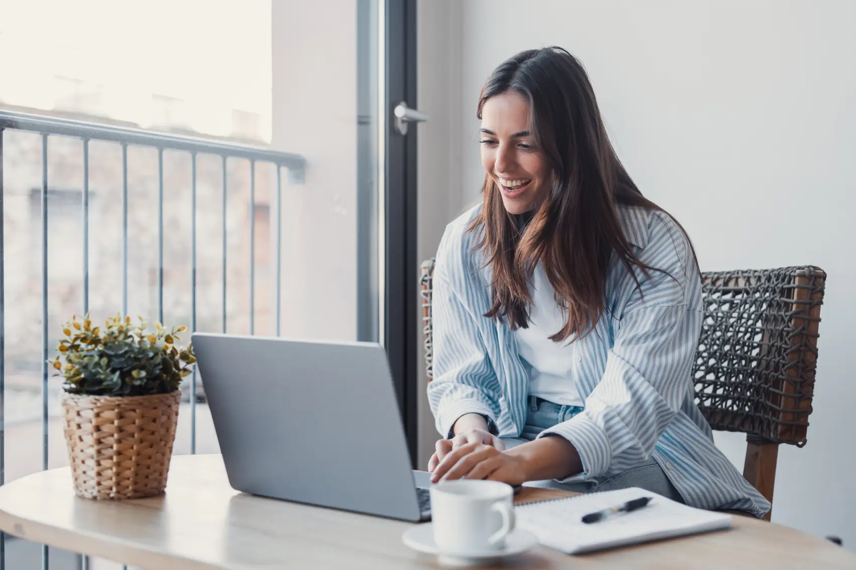 darf-e-imposto-de-renda Mulher positiva conversando com o cliente em uma chamada de vídeo no laptop, tomando notas, falando no computador, sentando na mesa de trabalho, usando dispositivos para comunicação de trabalho