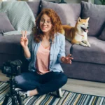 como-fazer-renda-extra mulher gravando com câmera e cachorro sentado no sofá