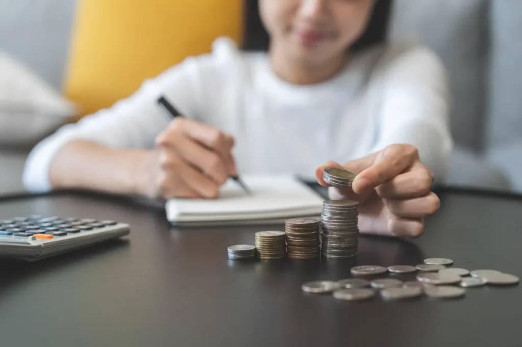 como aumentar o ticket médio​ - mulher com calculadora e moedas em uma mesa preta