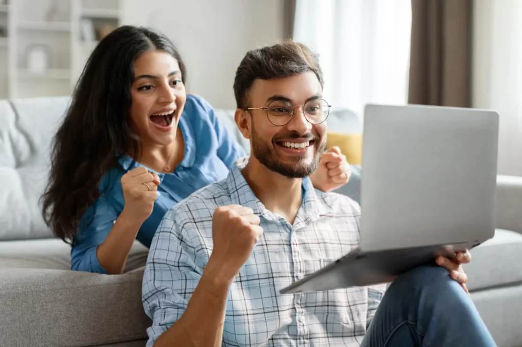 lucro fgts 2025 - homem e mulher em felizes em frente ao notebook