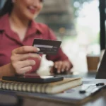 como funciona o juros do cartão de credito - Mulher de negócios mulher asiática usando laptop e cartão de crédito no trabalho