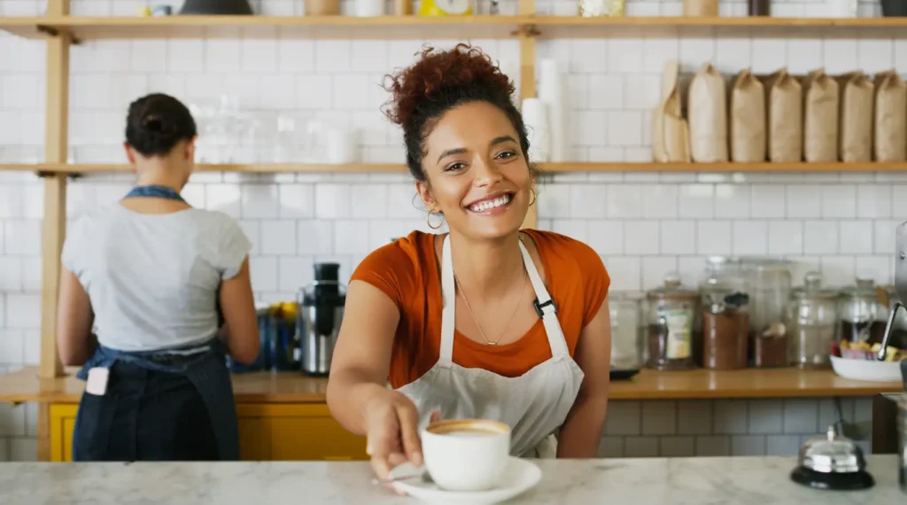 Dia do Café - barista feliz com caneca em restaurante