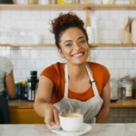 Dia do Café - barista feliz com caneca em restaurante
