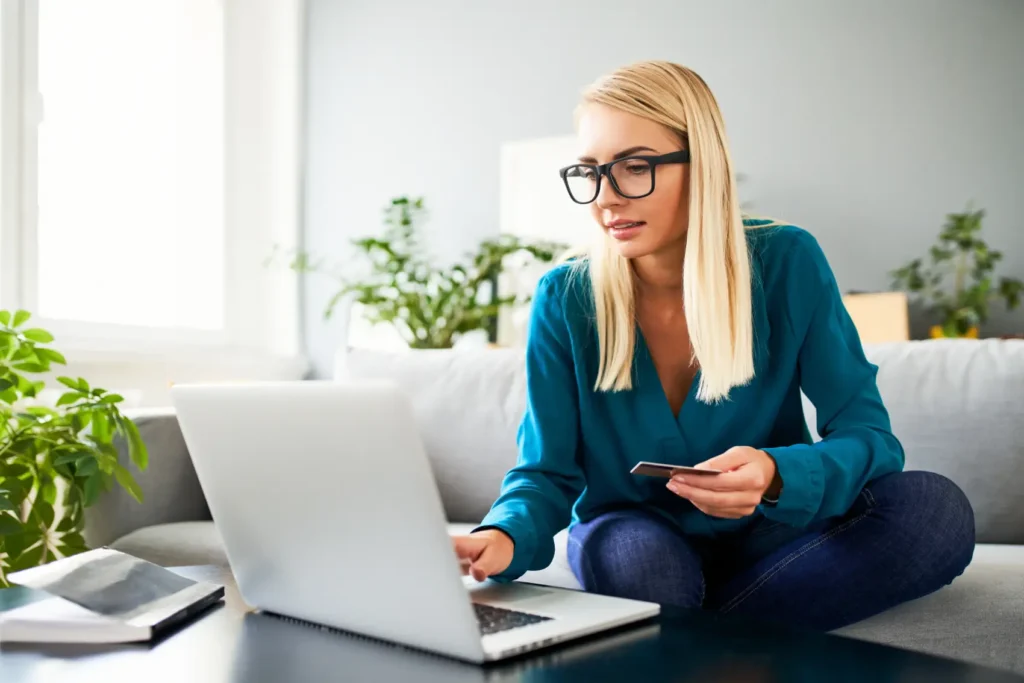 black friday 2026 - Compras on-line de mulher com cartão de crédito e laptop no sofá em casa