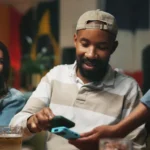 o que é nfc - homem paga no celular aproximando relógio inteligente