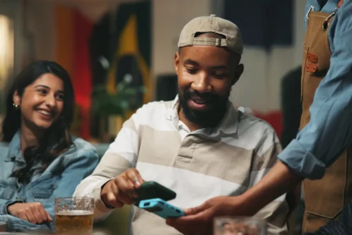 o que é nfc - homem paga no celular aproximando relógio inteligente
