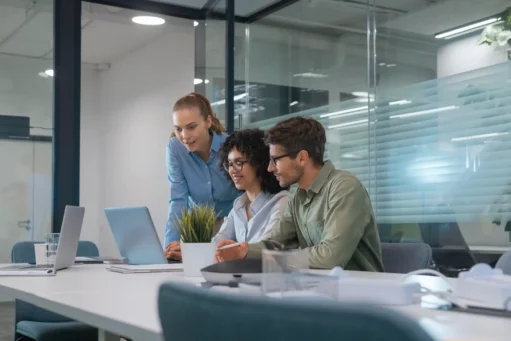 ferramentas de ia - Equipe de negócios multiétnicos que discute o novo projeto que trabalha em laptop no escritório moderno
