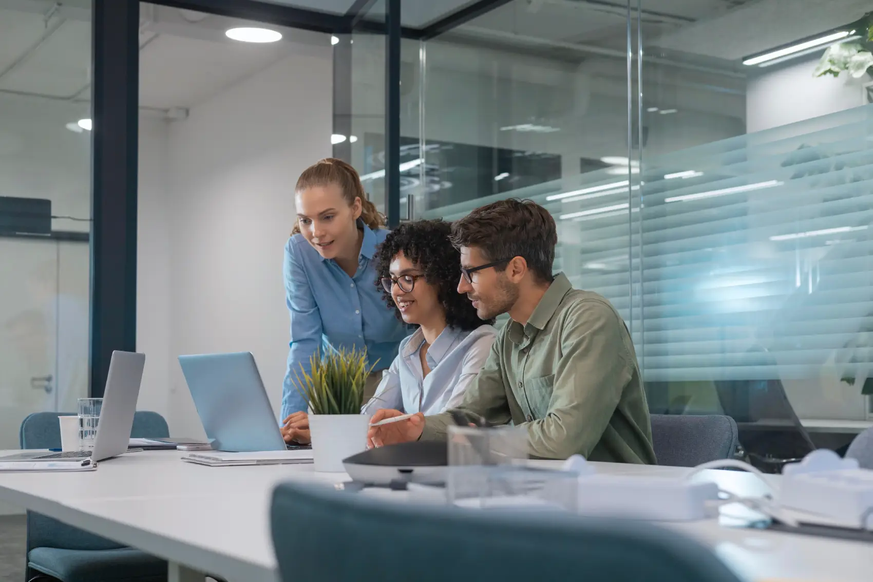 ferramentas de ia - Equipe de negócios multiétnicos que discute o novo projeto que trabalha em laptop no escritório moderno